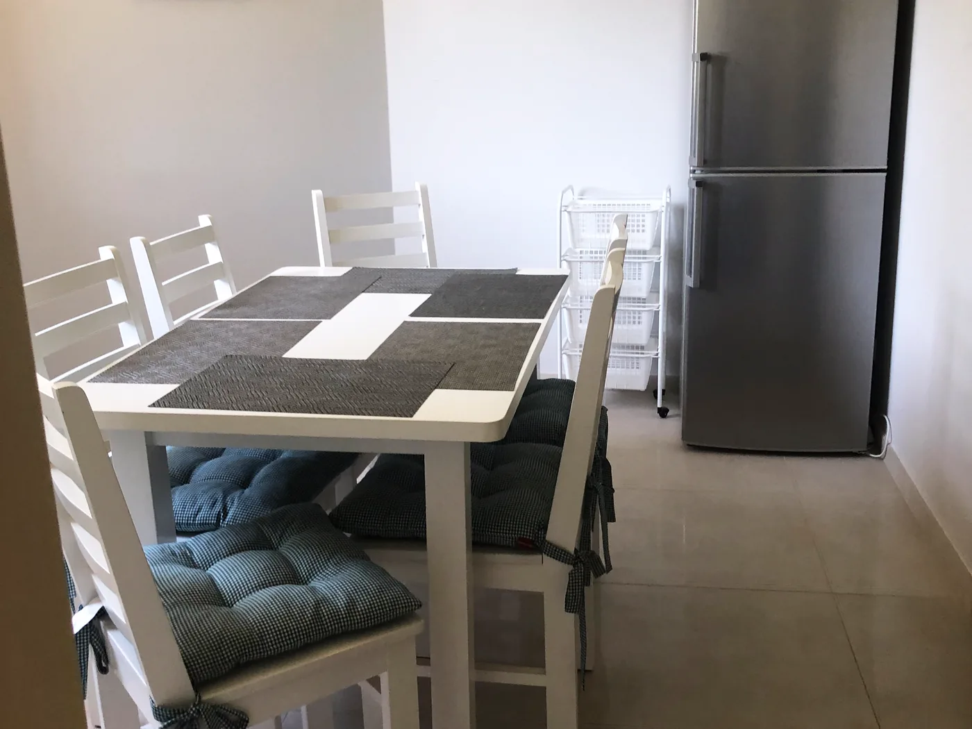 Apartament – jadalnia ze stołem dla 6 osób i lodówką